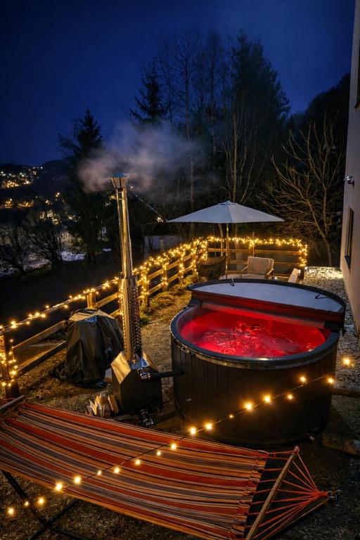 a hot tub with lights around it at night at Panoramic View Bran Rooms in Bran