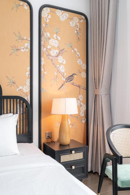 a bedroom with a bed and a table with a lamp at AviCasa T21 in Gò Công