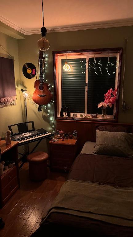 a bedroom with a bed and a desk and a window at The Travellers Den in Matosinhos