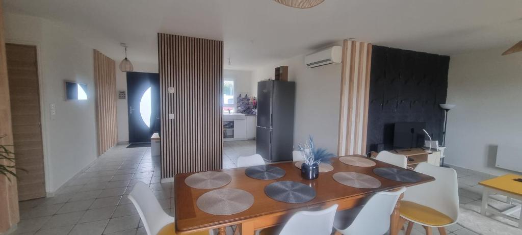 a dining room with a wooden table and chairs at Maison familiale tout équipée in Dunes