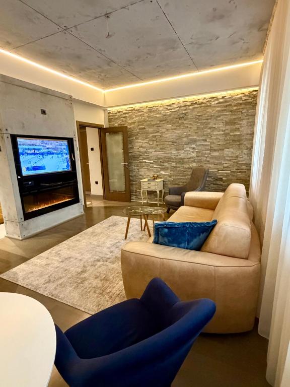 a living room with a couch and a tv at smgold lux apartman in Podgorica
