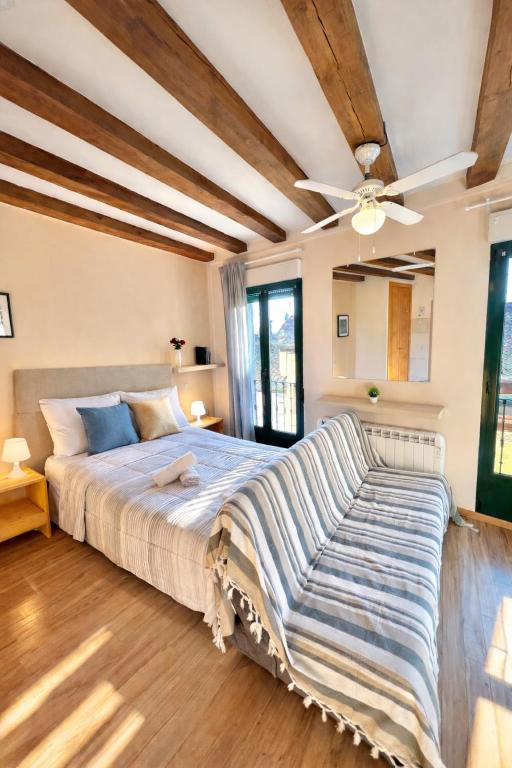 a bedroom with a large bed with a ceiling fan at Apartamento en Plaza Mayor de Segovia in Segovia