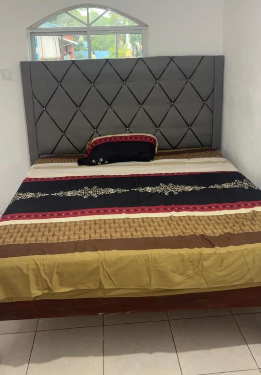 a bed with a black headboard and a pillow on it at Clarendons Finest in Toll Gate