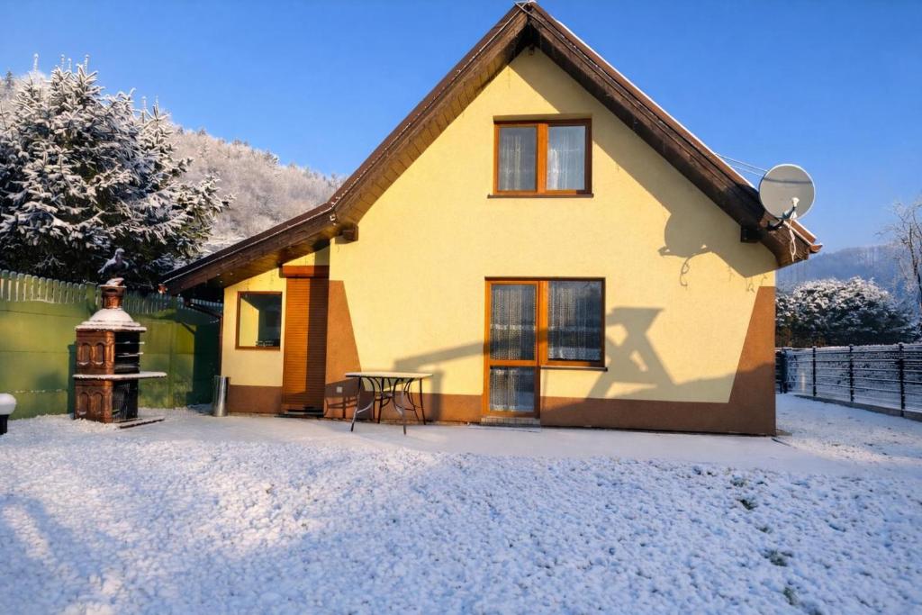 a yellow house with a table in front of it at Domek u Hani - domek 6 osobowy, z ogrodem i tarasem, Wisła in Wisła