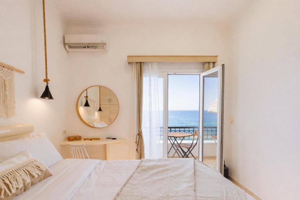 a bedroom with a bed and a view of the ocean at Golden Secret Beach House in Perissa