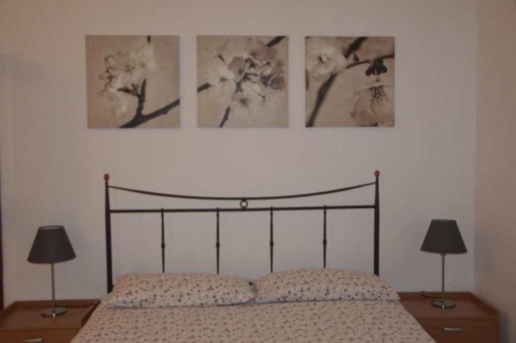 ナポリにあるArió Sweet Homeのベッドルーム1室(壁に3枚の写真が飾られたベッド1台付)