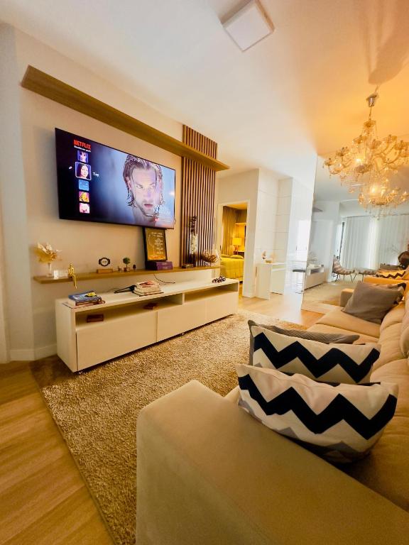 a living room with a flat screen tv on the wall at Casa Premium com Piscina Aquecida e Espaço Gourmet in Senador Canedo
