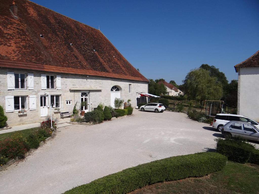 a white building with cars parked in a driveway at Gîte Le Four à Pain, 2 chambres, 2km du centre de Dole, in Dole