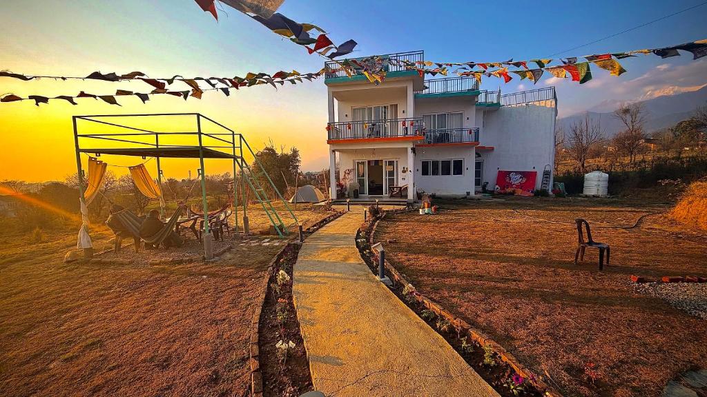 a house with a playground in front of a building at Social Monkey Hostel Bir in Bīr