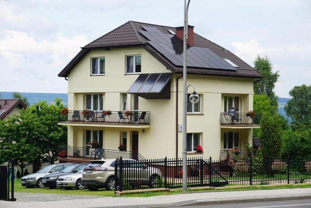 a large yellow house with a black roof at NOCLEGI Święta Katarzyna CENTRUM in Święta Katarzyna