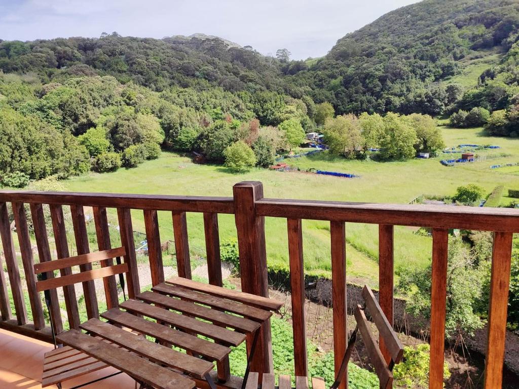 a wooden bench on a balcony with a view of a field at Fuerte El Mazo in El Dueso