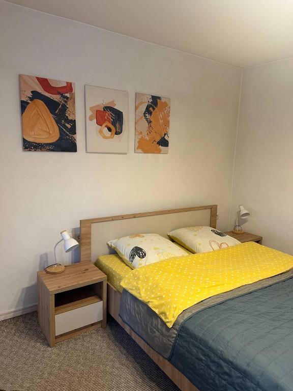 a bedroom with a bed and a table and pictures on the wall at Гостьовий двір in Yaremche
