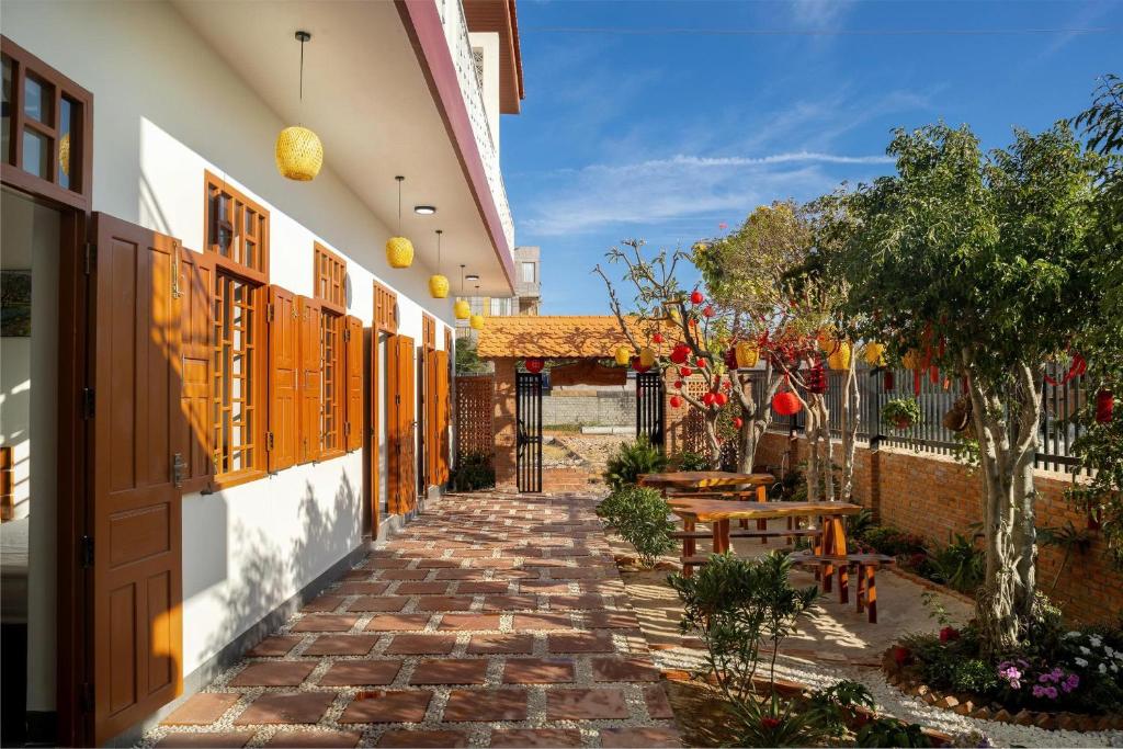 a walkway leading to a building with a patio at Homestay Hòn Đỏ Sea in Thôn Mỹ Tường