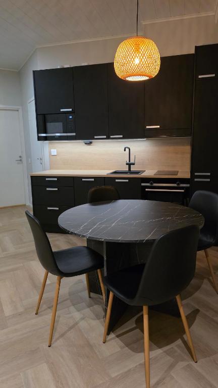 a kitchen with a black table and chairs and a sink at Studio Siivilla in Uusikaupunki