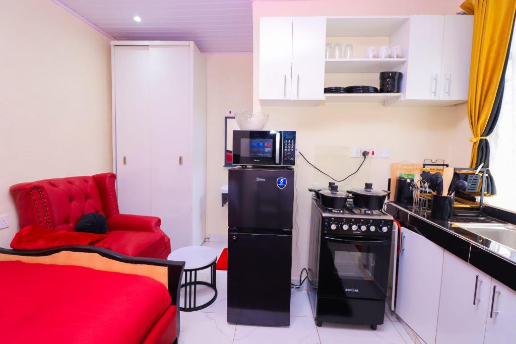 a small kitchen with a red chair and a microwave at The Haven in Nyeri