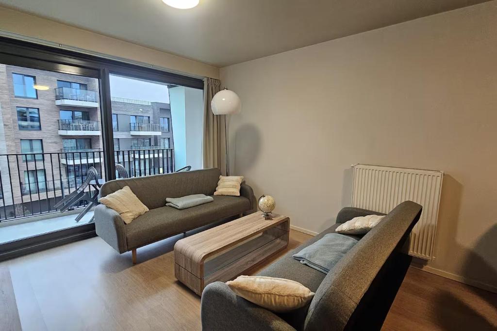 a living room with a couch and a window at Christel Residence in Ostend