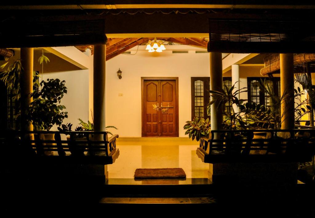 a front entrance to a house with a wooden door at Jotham Gardens in Alleppey
