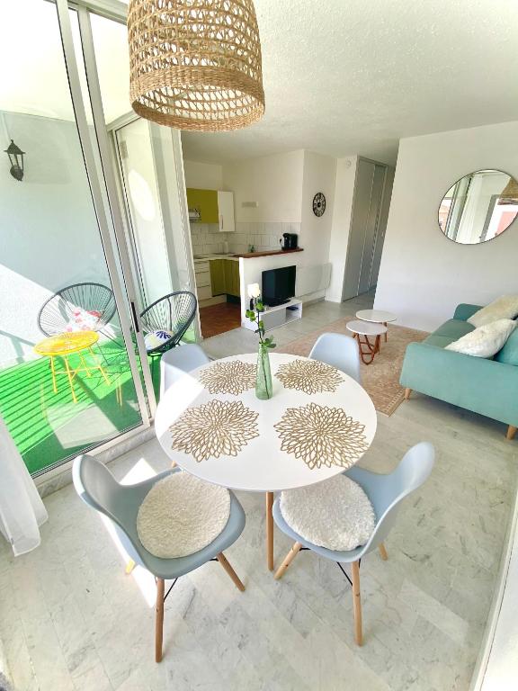 a living room with a white table and chairs at appartement T2 cabine cap d'agde in Cap d'Agde