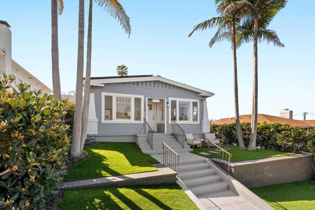 a small white house with palm trees and grass at Cliff View - Prime Downtown La Jolla in San Diego