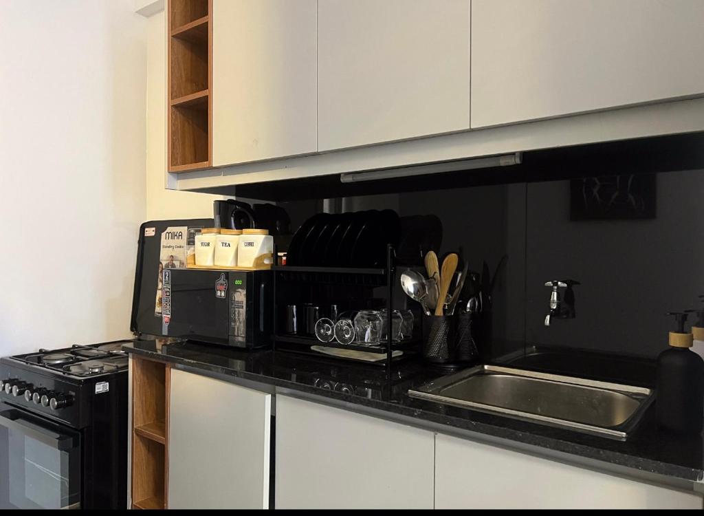 a kitchen counter with a sink and a microwave at Sk home in Kiambu
