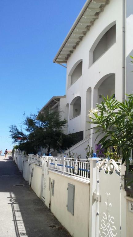 a white fence in front of a building at Midnight sun pomposa lido in Lido di Pomposa