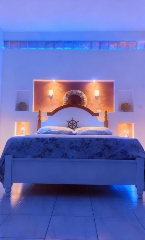 a bedroom with a large bed with blue lighting at Beach Village Rest in Tarrafal