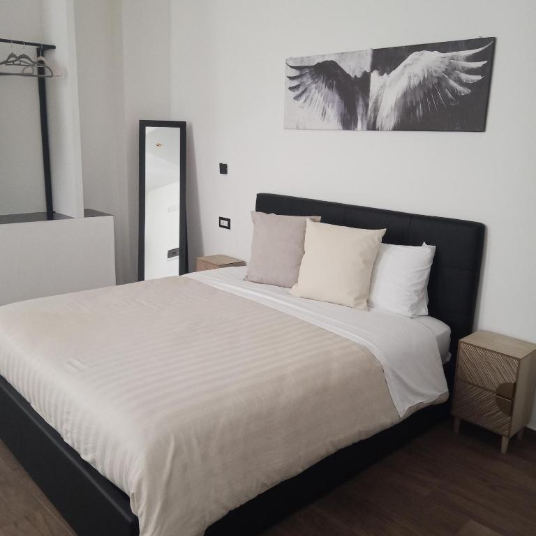 a bedroom with a large bed with white sheets at La Corte Guest House in Bari