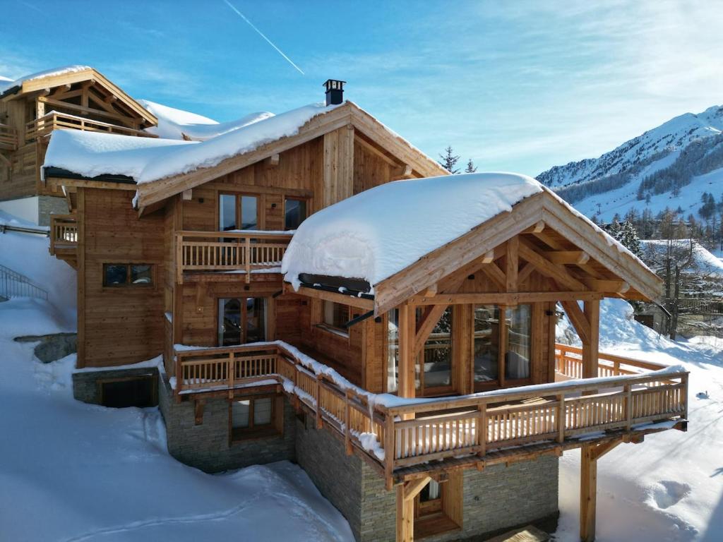 a log cabin with snow on the roof at Beautiful chalet with views in Montgenèvre