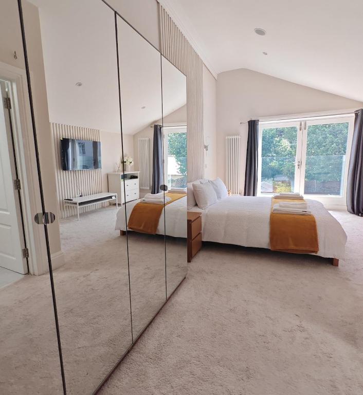 a bedroom with two beds and a large mirror at The Windsor Courtyard in Windsor