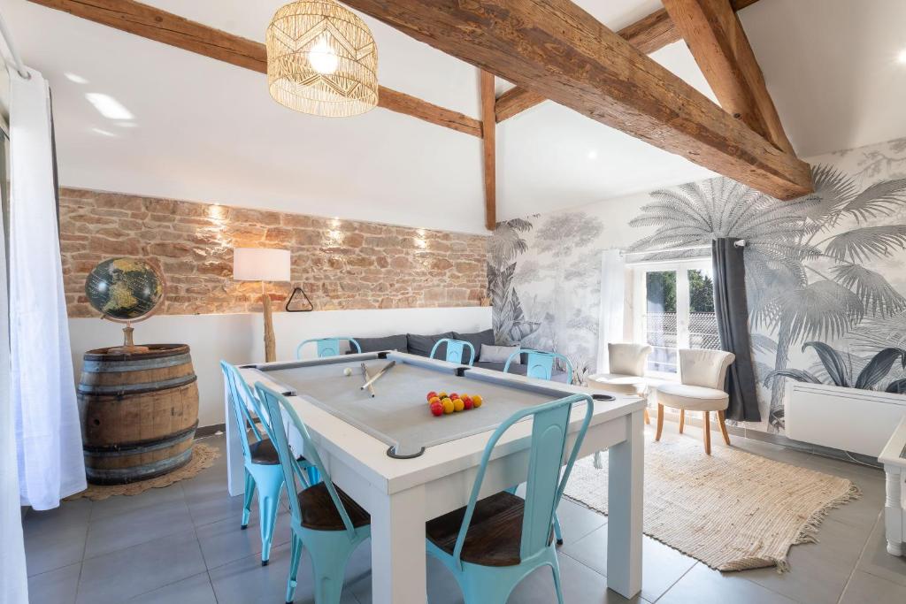 a dining room with a ping pong table and blue chairs at On dirait le Sud - Proche Mâcon SOLEIDOR in Mâcon