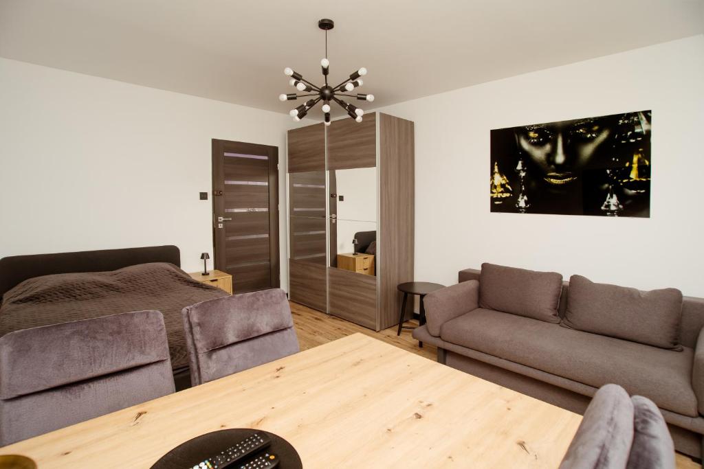a living room with a couch and a table at Kolbi Signature Platinum Residence in Białogard