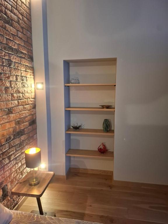 a living room with a table and a brick wall at Jūras ielas apartamenti in Limbaži