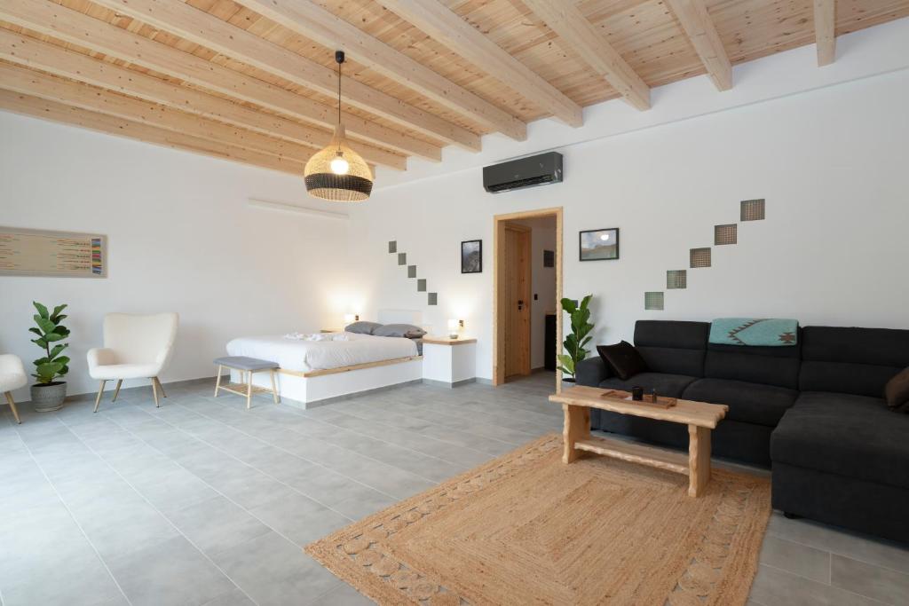 a living room with a couch and a bed at Sage Suite in Paránimfoi