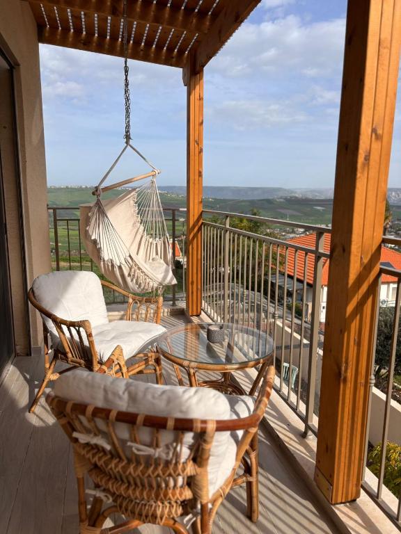 a porch with two chairs and a hammock at sunrise valley - זריחת העמק in Yavneʼel