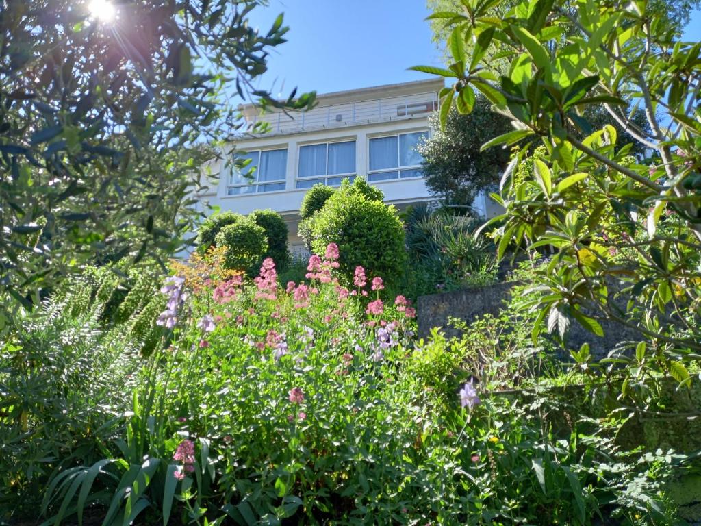 a garden with pink flowers in front of a building at Appartement Fort Lamalgue in Toulon