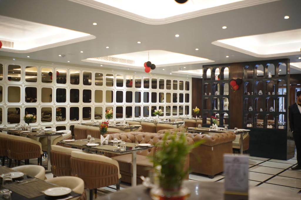 a restaurant with tables and chairs in a room at Hotel The Paradise in Bihār Sharīf