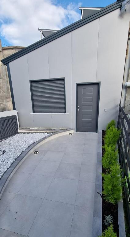a white building with a driveway and a door at MAG - Rooms and Apartment in Castelpoto