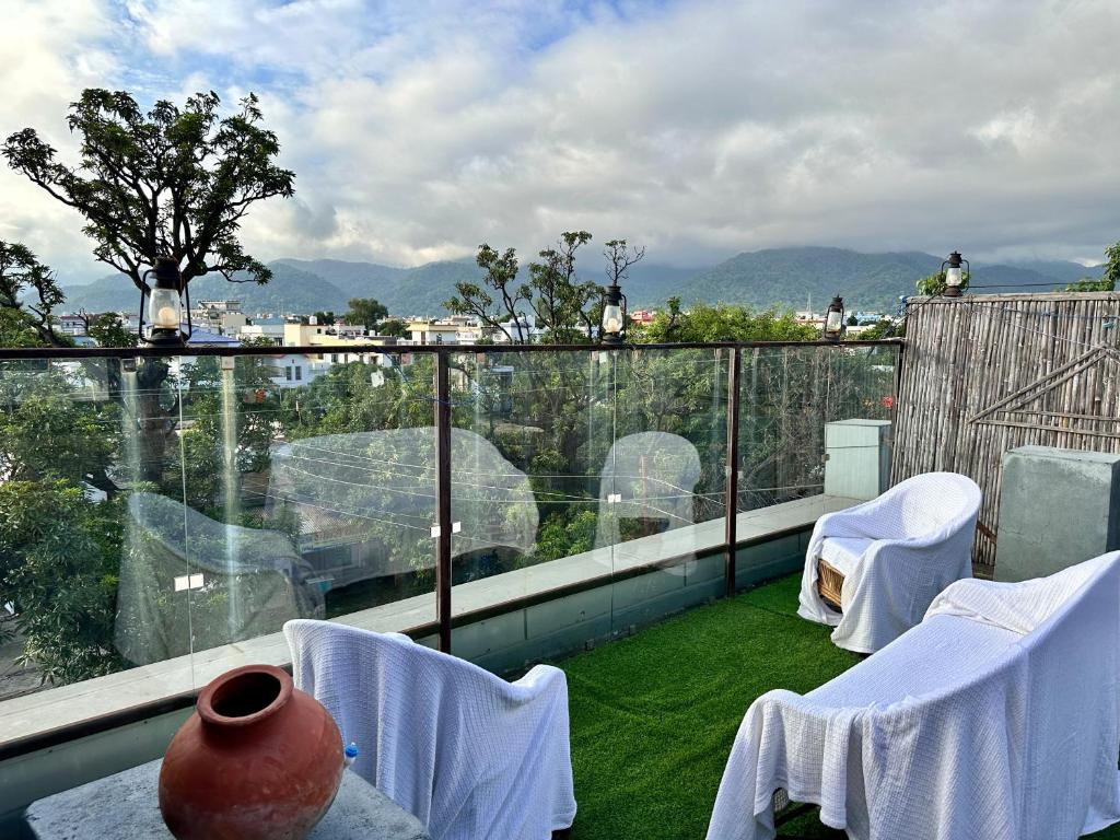 a balcony with chairs and a vase on a balcony at Hotel Tulsi in Haldwāni