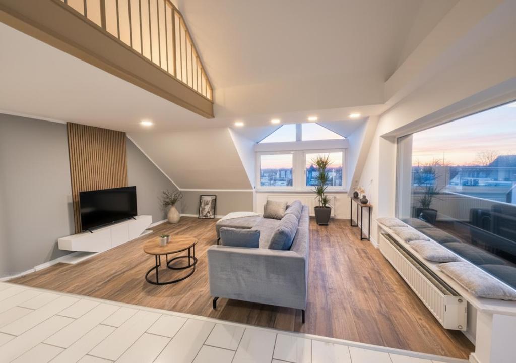 a living room with a couch and a tv at Sky Loft Schwarzach in Schwarzenbruck