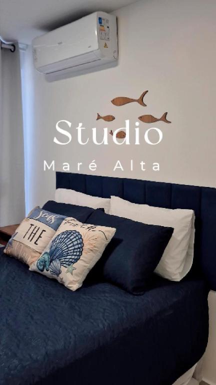 a bedroom with a blue bed with a sign on the wall at Apartamento Maré Alta in Tamandaré