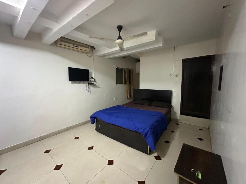a bedroom with a blue bed and a tiled floor at DIAMOND PALACE Kalasipalya in Bangalore