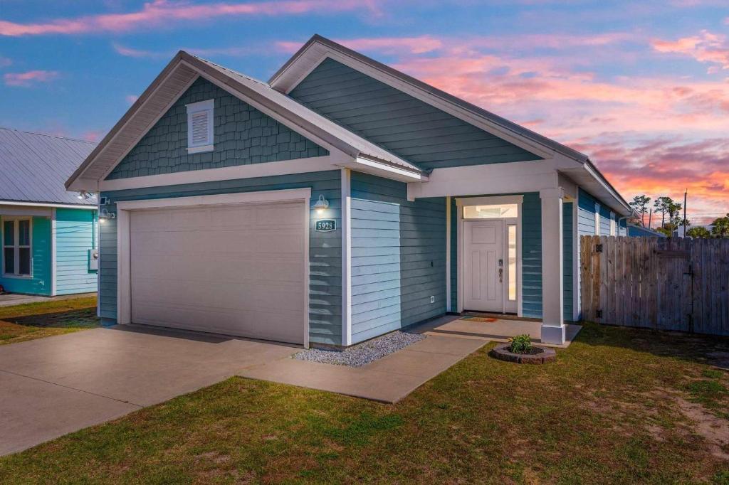 a blue house with a garage in a yard at Sunset Nirvana in Panama City Beach