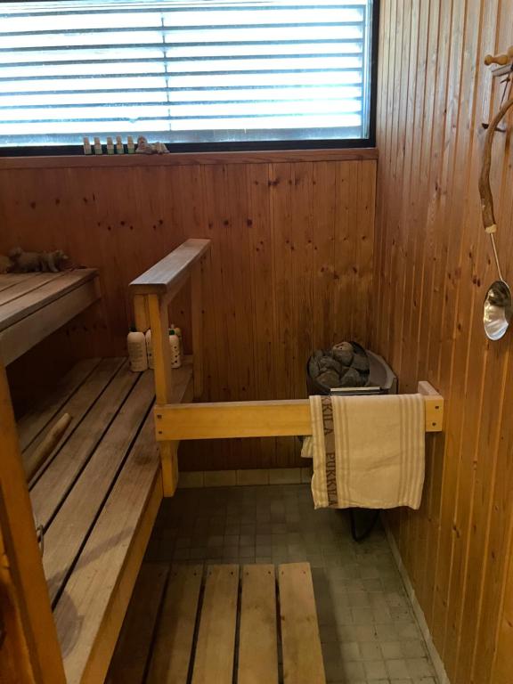 a room with a bench in a wooden room at Sunset Forest apartment in Joutsa