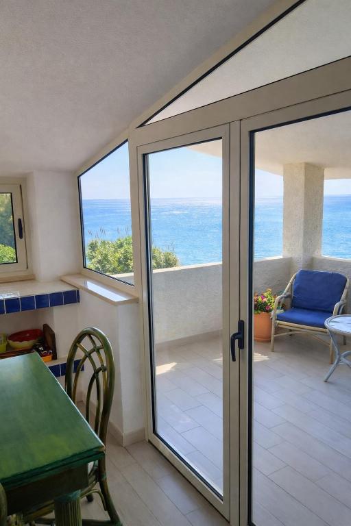 a room with a sliding glass door with a view of the ocean at Terrazza sul Mare Case Vacanze in Capo Rizzuto