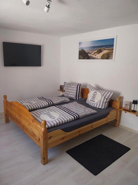 a wooden bed in a room with a tv at Fewo Helga in Glowe