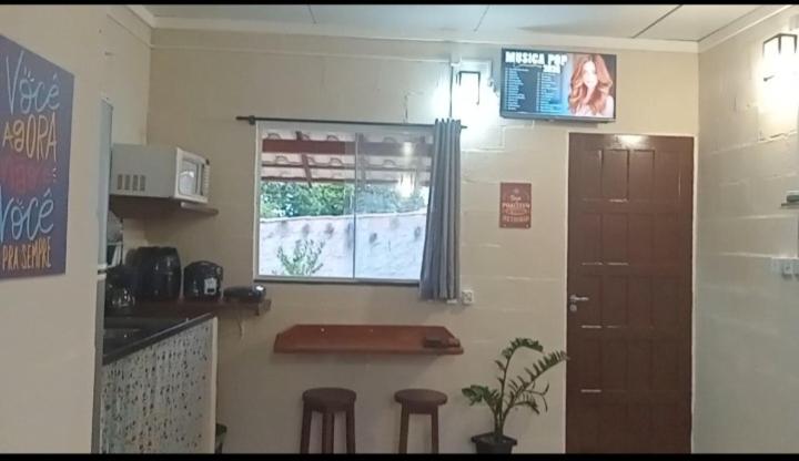 a kitchen with two bar stools and a window at Loft Caminho de Búzios in Cabo Frio