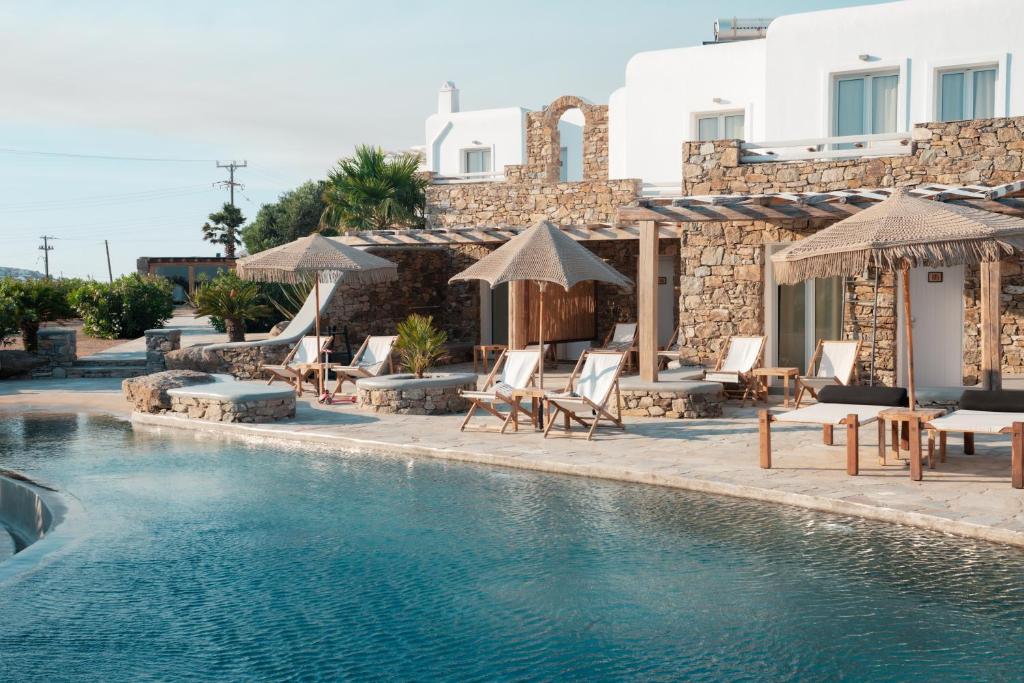 a resort with a swimming pool with chairs and umbrellas at Santa Maria Hotel in Elia Beach