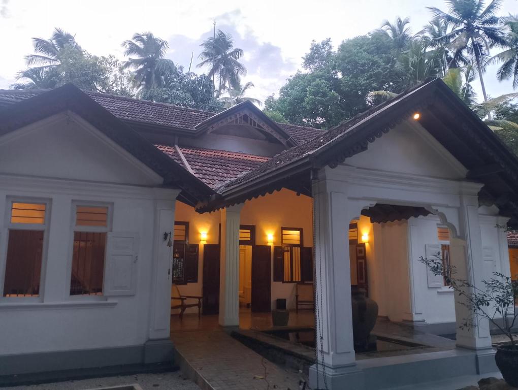a small white house with a roof at WG Villa Wathurugama in Kannimahara