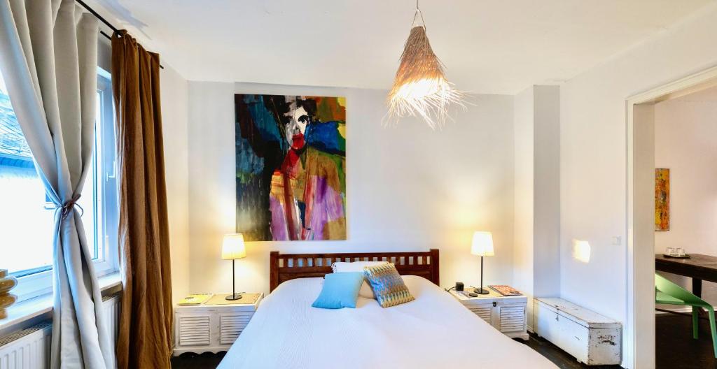 a bedroom with a bed with a painting on the wall at Schuhmacherei Rooms in Oestrich-Winkel
