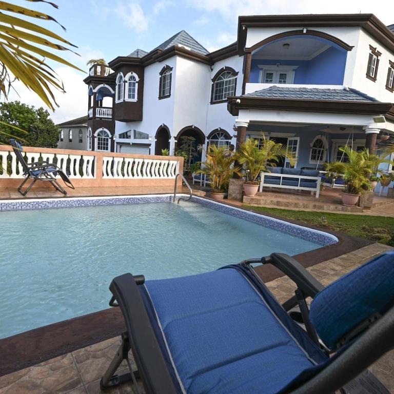 a pool with a lounge chair and a house at Dr Doc's Family Lodge with Pool in Spur Tree